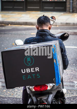 Uber isst Food Delivery Kurier für die nächste Lieferung Anfrage London UK Gig Wirtschaft UK wartet Stockfoto