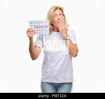 Mittleres Alter blonde Frau mit Menstruations Kalender ver isoliert Hintergrund decken den Mund mit der Hand mit Schande für den Fehler, den Ausdruck von Angst schockiert Stockfoto