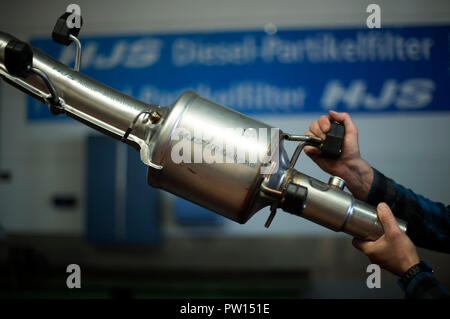 10 Oktober 2018, Nordrhein-Westfalen, Menden: Ein Mitarbeiter arbeitet an einem SCR-Katalysator für die Nachrüstung von Diesel für Stickstoff bei HJS in der Werkstatt. Foto: Ina Faßbender/dpa Stockfoto