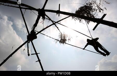 Kathmandu, Nepal. 12 Okt, 2018. Ein Jugendlicher spielt auf einer traditionellen Swing in der Feier der Dashain Festival in Kathmandu, Nepal, Okt. 12, 2018. Credit: Sunil Sharma/Xinhua/Alamy leben Nachrichten Stockfoto