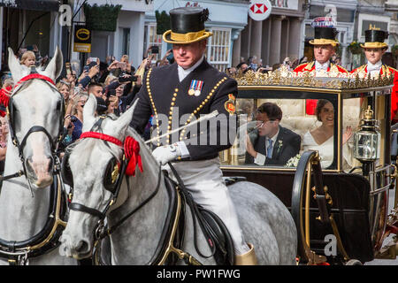 Windsor, Großbritannien. 12. Oktober, 2018. Ihre königliche Hoheit Prinzessin Eugenie, Frau Jack Brooksbank, und ihr Ehemann Jack Brooksbank eine Beförderung Prozession entlang Windsor High Street nach ihrer Hochzeit in St. George's Chapel in Windsor Castle genießen. Die geschlossenen schottischen Zustand Trainer war aufgrund der hohen Winde verwendet. Credit: Mark Kerrison/Alamy leben Nachrichten Stockfoto