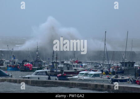 Lyme Regis, Dorset, Großbritannien, 12. Oktober, 2018: Großbritannien Wetter. Riesige Wellen, die durch Sturm Callum Hit der Cobb Hafen in Lyme Regis in Dorset. Credit: Savo Ilic/Alamy leben Nachrichten Stockfoto