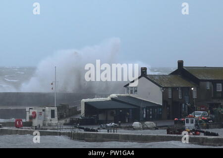 Lyme Regis, Dorset, Großbritannien, 12. Oktober, 2018: Großbritannien Wetter. Riesige Wellen, die durch Sturm Callum Hit der Cobb Hafen in Lyme Regis in Dorset. Credit: Savo Ilic/Alamy leben Nachrichten Stockfoto