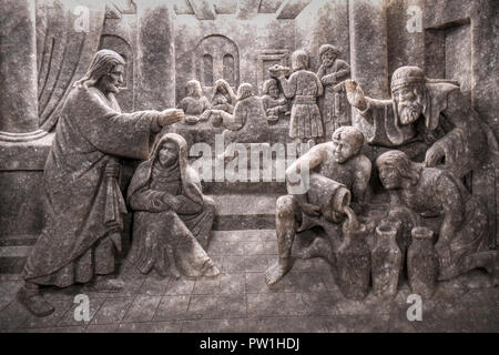 Ein Relief von Jesu Wunder, Wasser in Wein zu verwandeln, in der hl. Kinga Kapelle im Salzbergwerk Wieliczka in Krakau, Polen Stockfoto