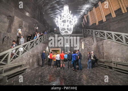 Touristische stehen um eine Statur von Papst Johannes Paul ll in der hl. Kinga Kapelle im Salzbergwerk Wieliczka in Krakau, Polen Stockfoto