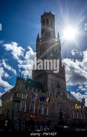Die hohen Glockenturm mit einer hellen Sonne Solar Flare in Brügge, Belgien, Europa an einem hellen Sommertag mit blauem Himmel Stockfoto