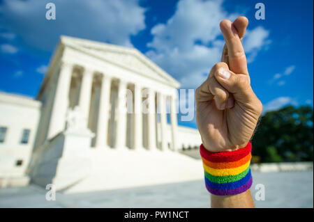 Hoffnungsvoll Hand tragen Gay Pride Regenbogen Flagge Armband drückt die Daumen für gutes Glück außerhalb der Supreme Court in Washington, DC, USA Stockfoto