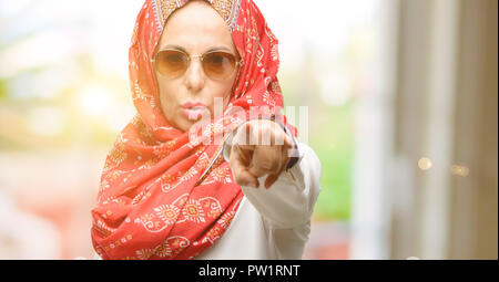 Mittleres Alter muslimisch-arabischen Frau, tragen, Hijab, der auf der Vorderseite mit Finger Stockfoto