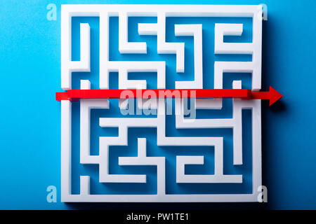 Ansicht der rote Pfeil über weiße Labyrinth auf blauem Hintergrund Stockfoto