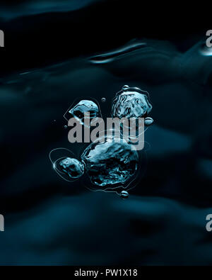 Luftblase Auftauchen auf dunklen Wasser Stockfoto