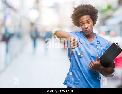 Afro-amerikanische Chirurg Arzt holding Zwischenablage Mann über isolierte Hintergrund mit Verärgerten Gesicht, negatives Vorzeichen zeigen Abneigung mit Daumen nach unten, Ablehnung Stockfoto