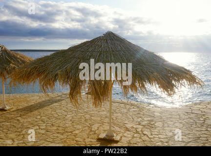 Sonnenschirm aus trockenen Blättern im Meer Sonnenuntergang in einem schönen Sommertag bewölkt Stockfoto