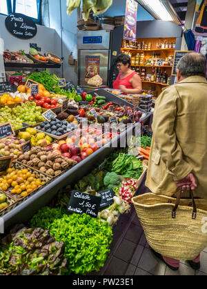 CONCARNEAU FALLENDEN INNEREN MARKT frischen französischen auf Verkauf französischen männlichen Shopper & Tasche in überdachten Markthalle Les Halles Concarneau Bretagne Frankreich produzieren Stockfoto