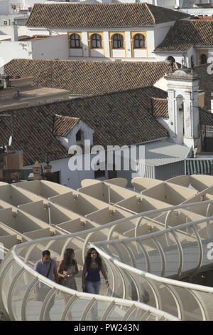 Erhöhten Blick auf die Dächer von Sevilla und seine Metropol Parasol Skulptur an La Encarnacion Platz, mit jungen Touristen flanieren auf der Oberseite. Stockfoto