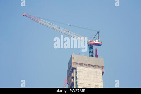 Neues modernes Gebäude und baukräne vor Ort. Stockfoto