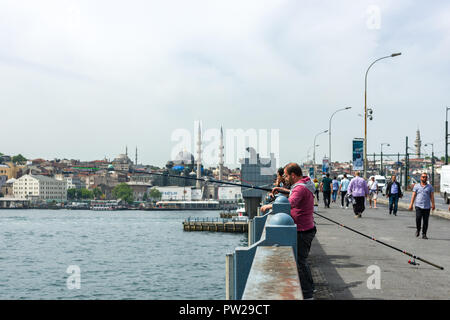 Eine Gruppe von Fischer auf der Galata Brücke mit ihren Angelruten über der Seite, Istanbul, Türkei Stockfoto