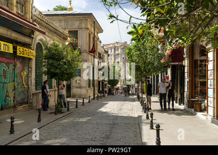 Eine typische Straßenszene im Stadtteil Beyoglu in Istanbul mit Menschen zu Fuß vorbei an Geschäften und Gebäuden, Istanbul, Türkei Stockfoto