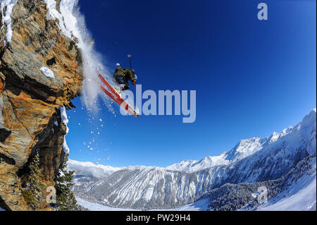 Ein Skifahrer springt von einer Klippe in den Französischen Alpen Courchevel. Blauer Himmel, Pulver, off-Piste. Stockfoto