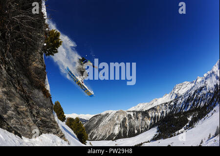 Ein Skifahrer springt von einer Klippe in den Französischen Alpen Courchevel. Blauer Himmel, Pulver, off-Piste. Stockfoto