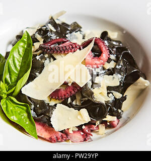 Pasta mit schwarzen Tintenfisch Tinte, Kraken und Parmesan. Stockfoto