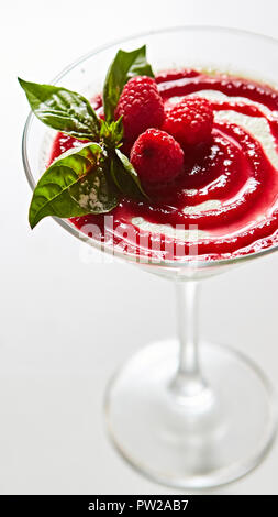 Köstliche italienische Dessert Panna Cotta mit Himbeeren in kleinen transparenten Glas Stockfoto