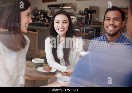 Lachende junge erwachsene Freunde Kaffee im Coffeeshop Stockfoto