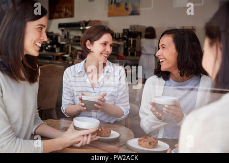 Vier Freundinnen entspannend über Kaffee im Coffeeshop Stockfoto