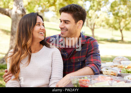 Junges Paar an einem Picknicktisch sitzen in einem Park Stockfoto