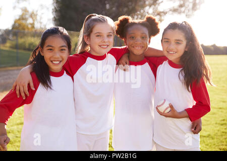 Schulmädchen Baseball Team Umarmen und Halten einen Baseball Stockfoto