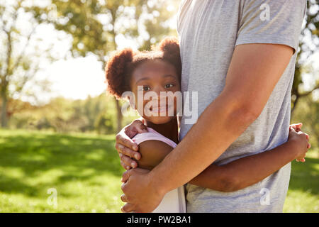 Nahaufnahme von Vater umarmt Tochter in Park Stockfoto