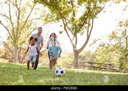 Familie zusammen spielen Fußball im Park Stockfoto
