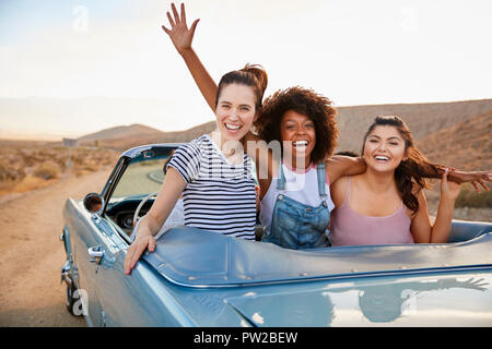 Portrait von drei weiblichen Freunde genießen Reise in oben offenen Classic Car Stockfoto