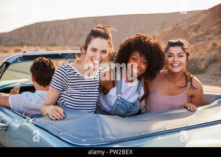 Portrait von drei weiblichen Freunde genießen Reise in oben offenen Classic Car Stockfoto