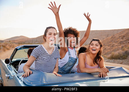 Portrait von drei weiblichen Freunde genießen Reise in oben offenen Classic Car Stockfoto