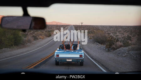 Eine Gruppe von Freunden auf Autofahrt Classic Cabrio gesehen durch die Windschutzscheibe von folgenden Fahrzeug Stockfoto