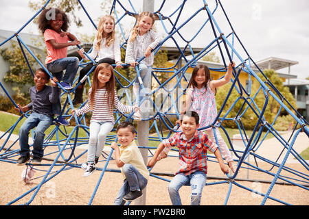 Grundschule Kinder Klettern in der Schule Spielplatz Stockfoto