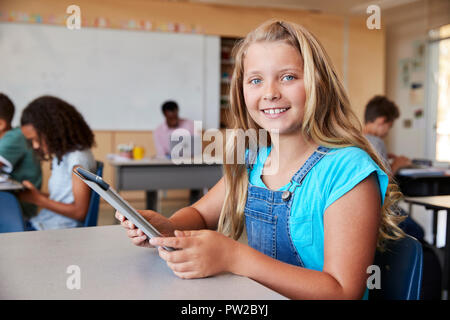 Mädchen mit Tablet in der Schule Klasse lächelnd in die Kamera ganz nah Stockfoto