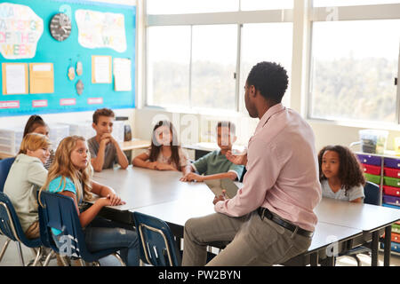 Männliche Lehrer mit der Volksschule Kinder in der Klasse zu besprechen Stockfoto