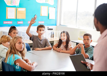 Schüler Hand in der Grundschule Klasse zu beantworten Stockfoto