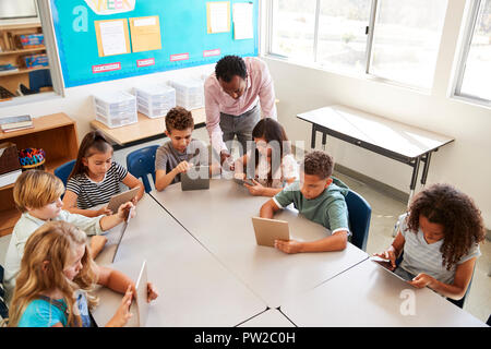 Lehrer Hilfe für Kinder mit Tabletten in Lektion, Erhöhte Ansicht Stockfoto