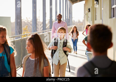 Männliche Lehrer und Schüler Spaziergang auf der Volksschule Campus Stockfoto