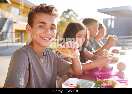 Junge an der Volksschule Mittagstisch lächelnd in die Kamera Stockfoto