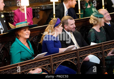 Sarah, die Herzogin von York, Prinzessin Beatrice von York und Peter Phillips nehmen ihre Plätze vor der Hochzeit von Prinzessin Eugenie an Jack Brooksbank im St George's Chapel in Windsor Castle. Stockfoto