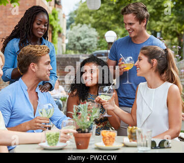 Freunde am Tisch in der Kneipe Garten genießen zusammen trinken Sitzen Stockfoto