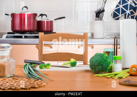 Brokkoli und Gemüse auf den Tisch und Schneiden mit einem Messer in der Küche zu kochen. Stockfoto