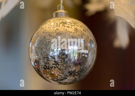 Silber große Christmas Ball hängen an Ästen am Weihnachtsmarkt. Es spiegelt Weihnachtsbeleuchtung Frankreich Stockfoto