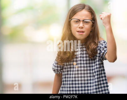 Brunette hispanische Mädchen Brille genervt und frustriert schrie mit Zorn, verrückt und schreien mit erhobener Hand, Wut Konzept Stockfoto