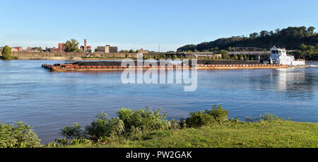 Tugboat Kohle schieben geladen Lastkähne, Ohio River, Parkersburg im Hintergrund. Stockfoto