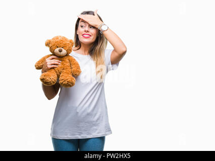 Junge schöne Frau mit teddybär Plüsch über isolierte Hintergrund mit Hand betonte am Kopf, mit Scham und Überraschung Gesicht schockiert, wütend und fr Stockfoto