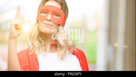 Junge super hero Frau mit Cape, Finger, die Nummer eins Stockfoto